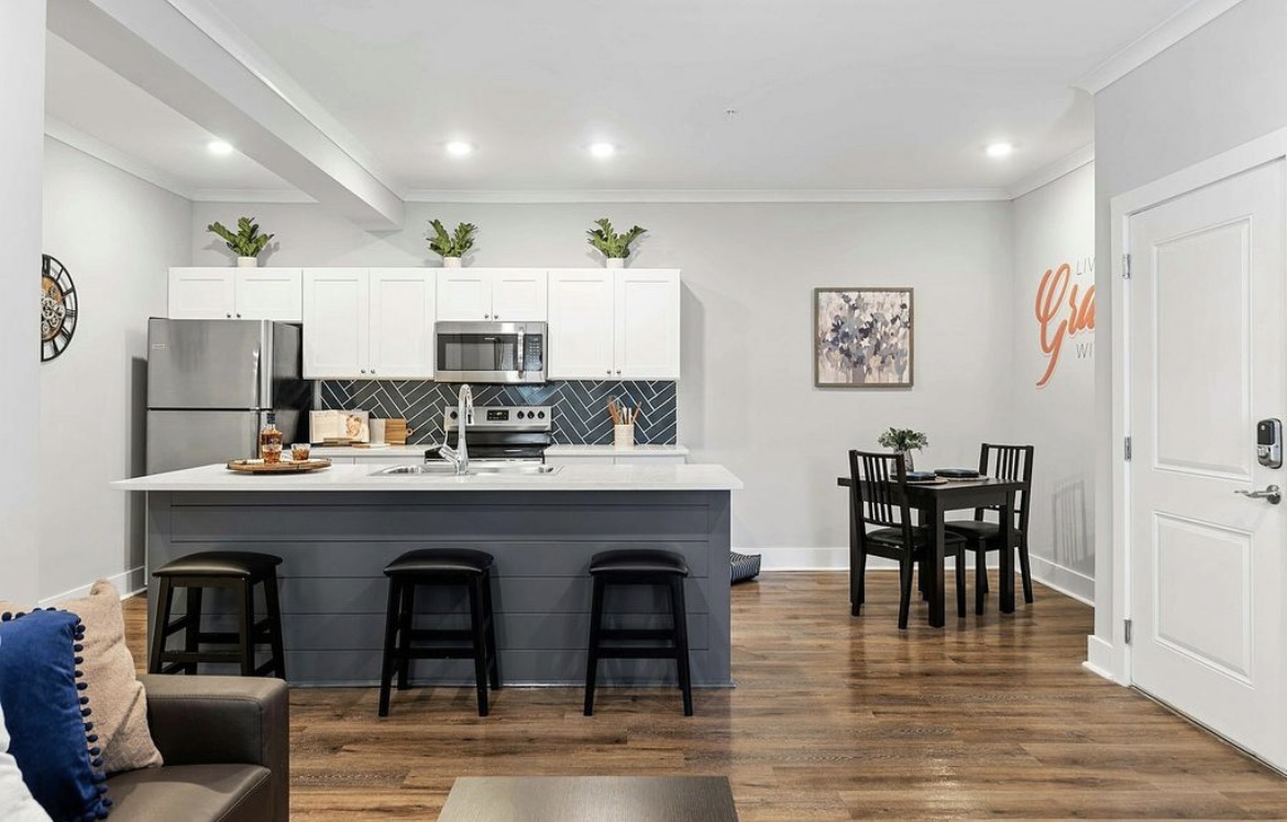 Open kitchen island with bar stools and a dining table for four
