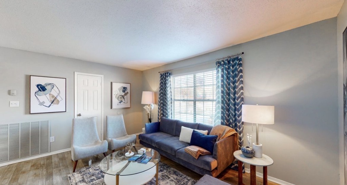 Second view of the living room with sofa, twin armchairs and bright window
