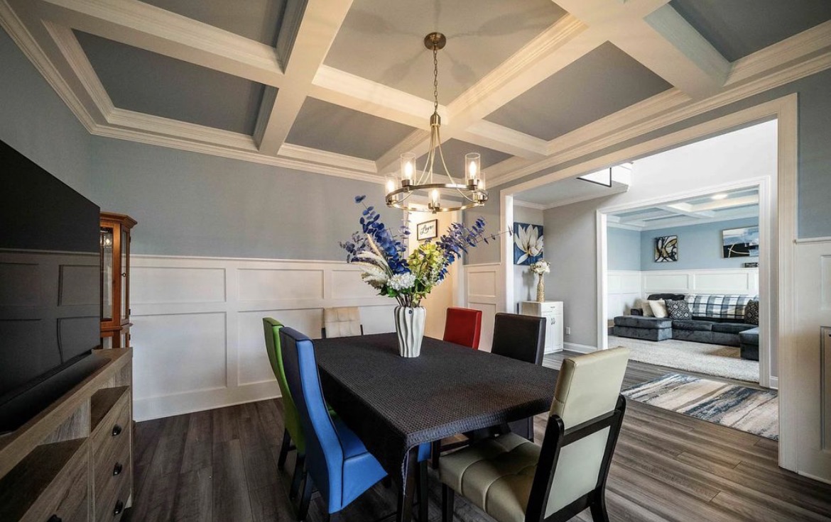 Formal dining room with coffered ceiling, chandelier and table for six